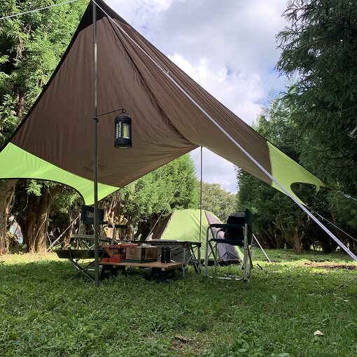 森の中にキャンプテントが張られている。中にはテーブルとイスが二脚置かれている